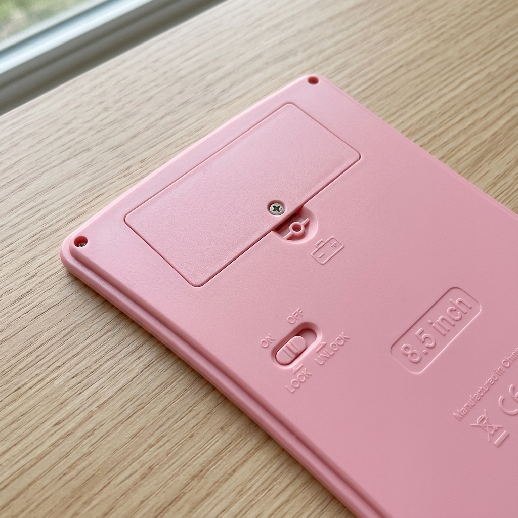 Close-up of the screw-secured battery compartment and lock switch on the back of the tablet